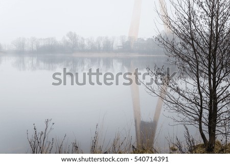 heavy mist over the river in autumn with calm water