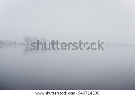 heavy mist over the river in autumn with calm water