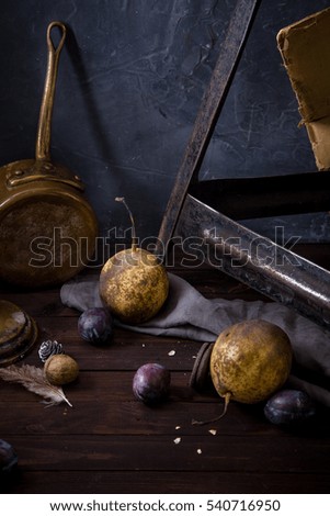 Pears and plums on rustic background. Dark food concept