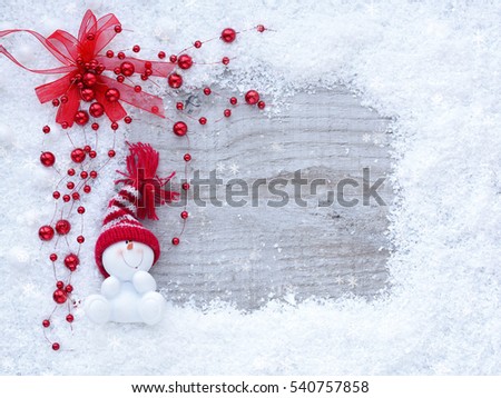 Frame of snow with snowmen on wooden background with space for your text