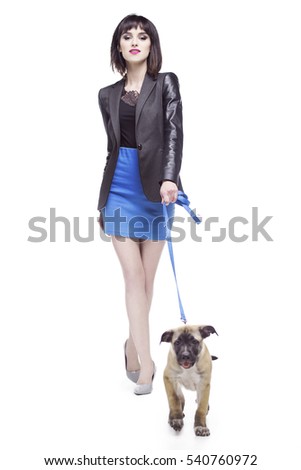 Pretty woman walking with a small dog on a leash