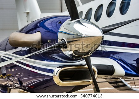 Closeup high detailed view of engine and airscrew of modern turboprop airplane standing on parking place at airport. Royalty-Free Stock Photo #540774013