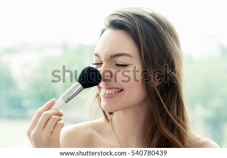 Beautiful girl with cosmetic powder brush for make up. Makeup. Make-up applying  for perfect skin.