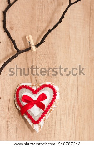 Love concept. St Valentines family couple passion card. Bright red  and white hand made heart with bow hanged on a wooden textured brown background. Scandinavian loft decoration. 