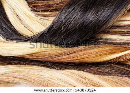 Real woman hair texture. Human hair weft, Dry hair with silky volumes. Real european human hair wallpaper texture. Brown blond dark blonde and black.