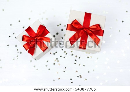 Two presents with red bow on white wooden rustic surface. Festive picture made in flat lay style with place for text.