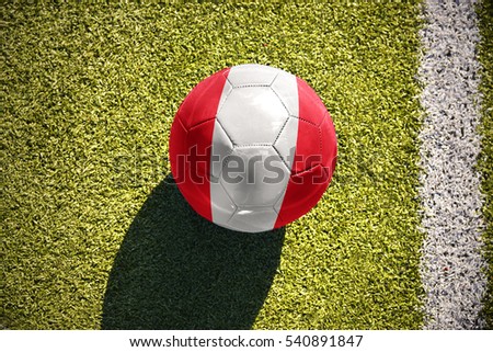 football ball with the national flag of peru lies on the green field near the white line
