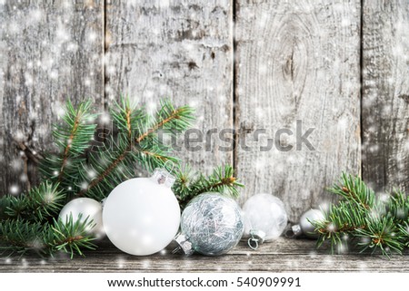 Silver and white christmas ornaments, xmas tree on rustic wood background with blurred snow. Merry christmas greeting card. Winter holiday theme. Happy New Year. Space for text
