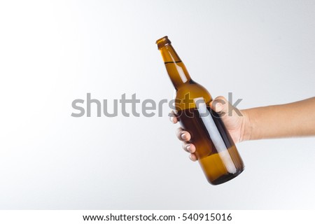 Hand holding a beer bottle without label isolated on white background Royalty-Free Stock Photo #540915016