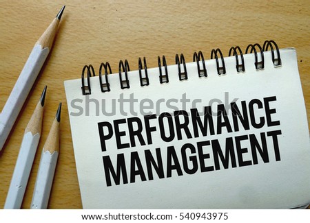 Performance Management text written on a notebook with pencils