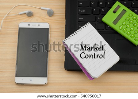 Market control text written on a notebook. Wooden background with laptop,phone and calculator. Business and management concept.