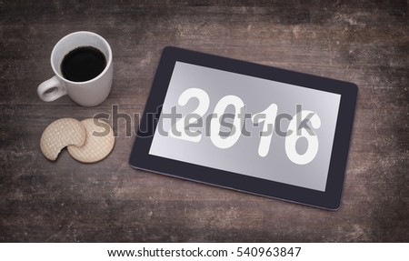 Tablet touch computer gadget on wooden table, vintage look - 2016