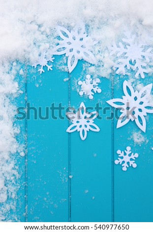 Winter pattern with snowflakes. Blue wood texture with snow Christmas background.
