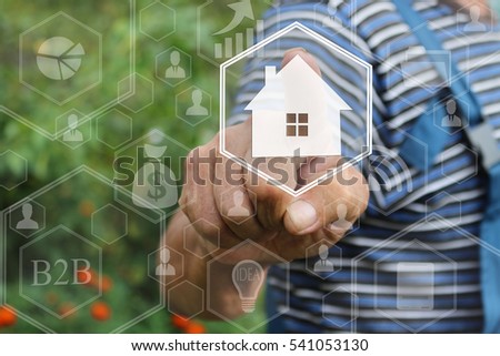 The concept of finding housing for rent or purchase . Farmer businessman clicks with web icon Home on the touch screen in the web network . Tanned hands, male hands of an elderly person . 