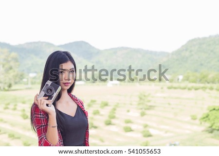 Young hipster woman photographer holding a vintage camera. 