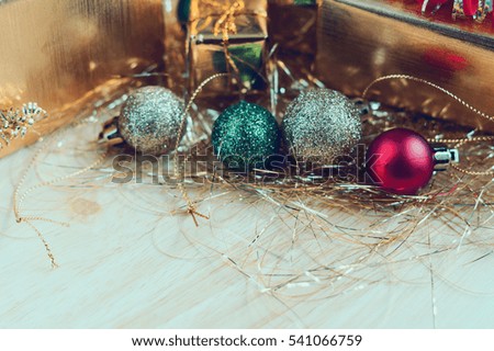 golden gift box with christmas ornaments on wood table for christmas background
