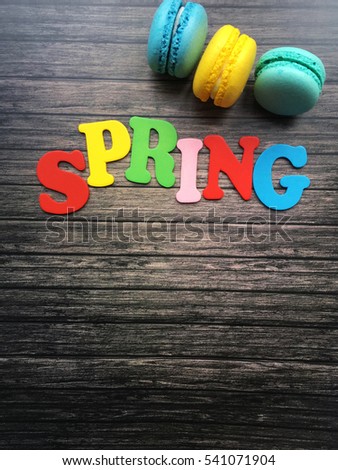 Spring wooden letters. Spring wooden word with macaroons on wooden background. Hello spring. Spring wallpaper. 