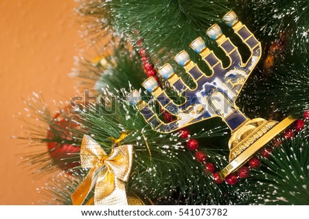 Jewish menorah on a decorated Christmas (New Year) tree. In December 2016 Jewish holiday Hanukkah coincides with Christmas and New Year. 