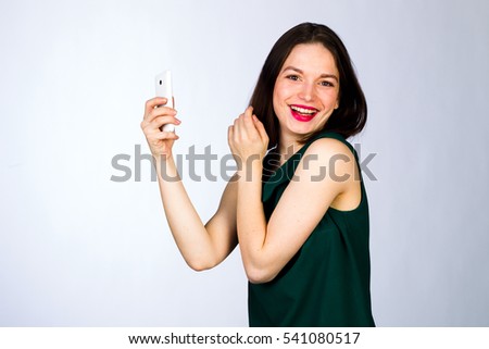 Young girl with mobile cell phone on a white background, studio lighting