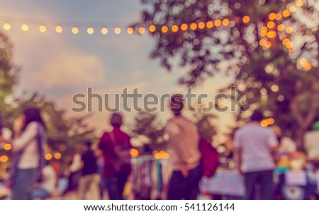 abstract blur image of food stall at day festival in garden with bokeh for background usage . (vintage tone)