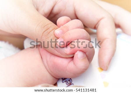 close-up hand of baby in the hand of mother. Royalty-Free Stock Photo #541131481
