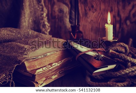 retro objects feather and leaher book with candle light