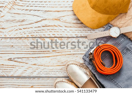 Woman Fashion set for clothing with Sweater Jeans Shoes Belt Watch and baseball cap on wooden background - Vintage light Filter