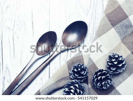 Wooden spoons and pine cones on a white old wooden surface. Preparation by new year, a festive background