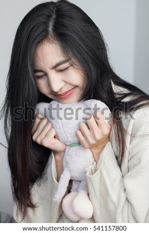 Asian girl hug her doll.