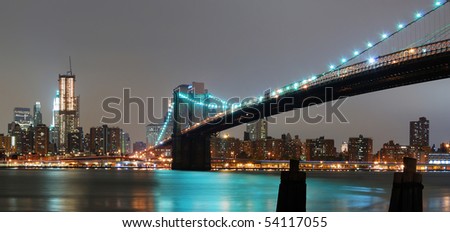 New York City night panorama with Brooklyn bridge and Manhattan skyline.