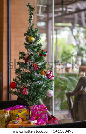 Christmas tree with toys. Green tree decorated with colorful toys and a lot of boxes with gifts.