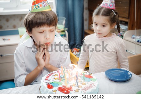 brother and sister sitting at home cake