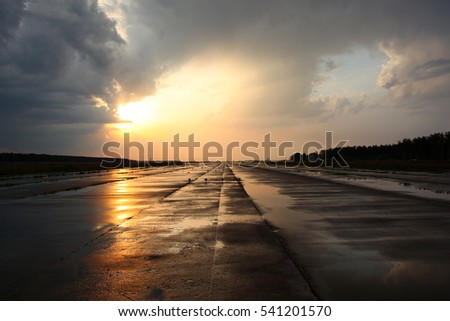 Airport runway after rain during sunset. Royalty-Free Stock Photo #541201570