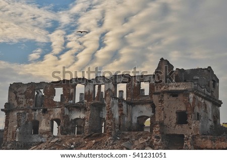 Damaged building under the beautiful cloudy sky. 
