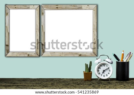 Wooden workplace desktop with table clock, plants, Frame on old wooden table.