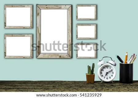 Wooden workplace desktop with table clock, plants, Frame on old wooden table.