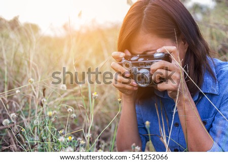 Vintage of beautiful women photography standing hand holding retro camera with sunrise,dream soft style