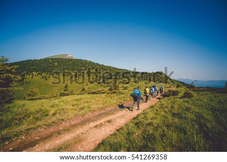 A group of tourists go to a top of mountain. Royalty-Free Stock Photo #541269358