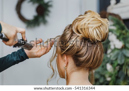 Hairdresser working at the beauty studio salon, making hair style. Royalty-Free Stock Photo #541316344