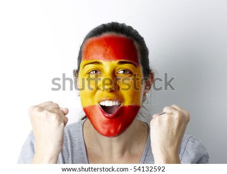 Spanish fan screaming GOAL with hands up and painted flag on her face.