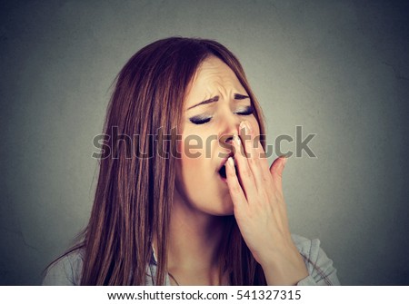 sleepy woman with wide open mouth yawning eyes closed looking bored isolated on gray wall background. Face expression emotion body language