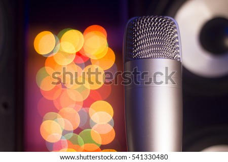 Condenser microphone in a studio. Musical speaker. Christmas garlands