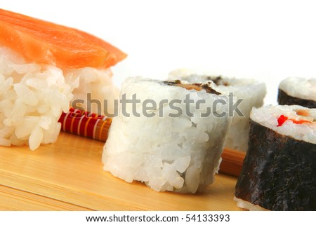 mixed sushi rolls on wooden plate over white