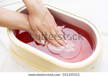 process paraffin treatment of female hands in beauty salon Royalty-Free Stock Photo #541339312