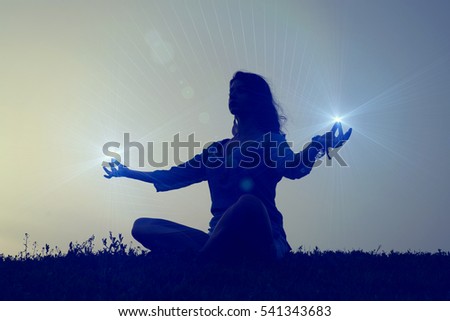 The female energy - concept. Silhouette of a woman meditating in the lotus position. Royalty-Free Stock Photo #541343683