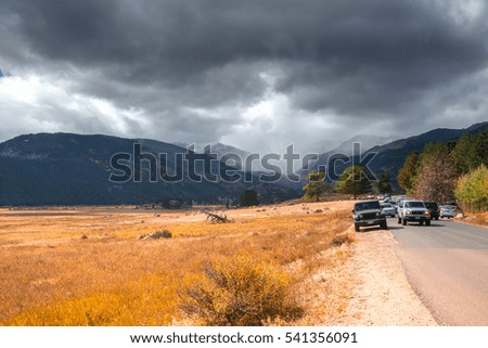 Amazing view of mountains. Dramatic landscape with gray stormy sky. Scenic view of the mountains. Autumn foliage. Tourist stopped on the road to take beautiful panoramic pictures. Colorado peaks.