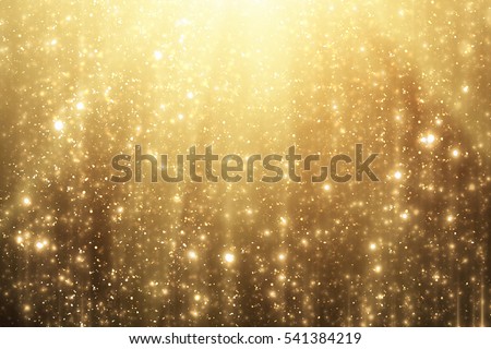 Golden rays and sparkles or glitter lights. Merry Christmas festive background.defocused circle bokeh or particles Royalty-Free Stock Photo #541384219