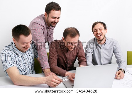 Four men laugh sincerely while working