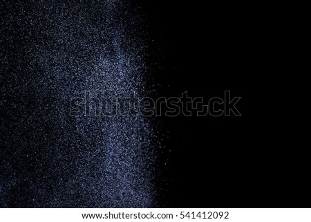 Abstract blue splashes of water on black background. Freeze motion of white particles. Rain, snow overlay texture.