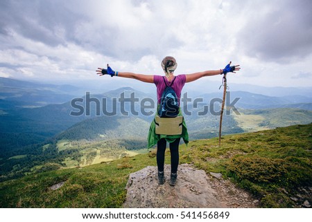 Girl is standing on top of the rock and enjoying the view.
A girl on top look on landscape of mountains. Royalty-Free Stock Photo #541456849
